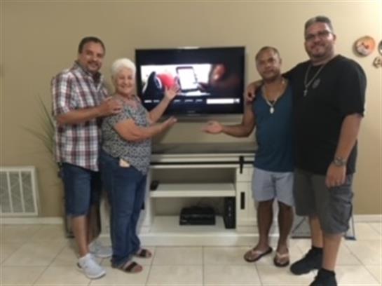 Family members celebrate happily together in their living room with a new entertainment system.