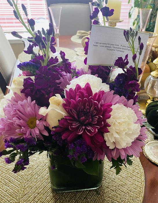 Vibrant purple, pink, and white flowers in a decorative vase enhance the dining atmosphere.
