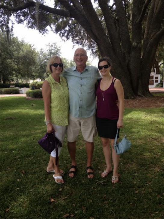 Friends pose together in a park under a large tree while enjoying a sunny afternoon.