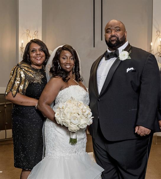 A joyous couple celebrates their wedding, surrounded by family in elegant attire.