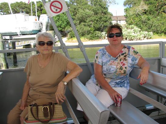 Two women sit comfortably on a boat, enjoying the warm weather and the surroundings.