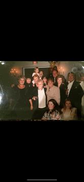 Group of friends enjoying a lively celebration in a banquet hall during the evening hours.