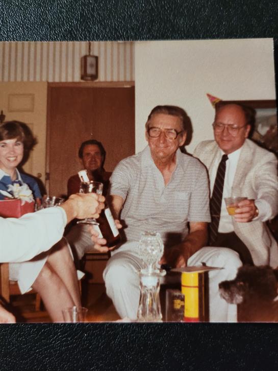 Group of friends enjoy drinks and conversation in a warm, inviting room on a cheerful evening.