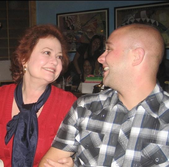 A cheerful couple shares a warm smile while engaged in conversation at a restaurant.