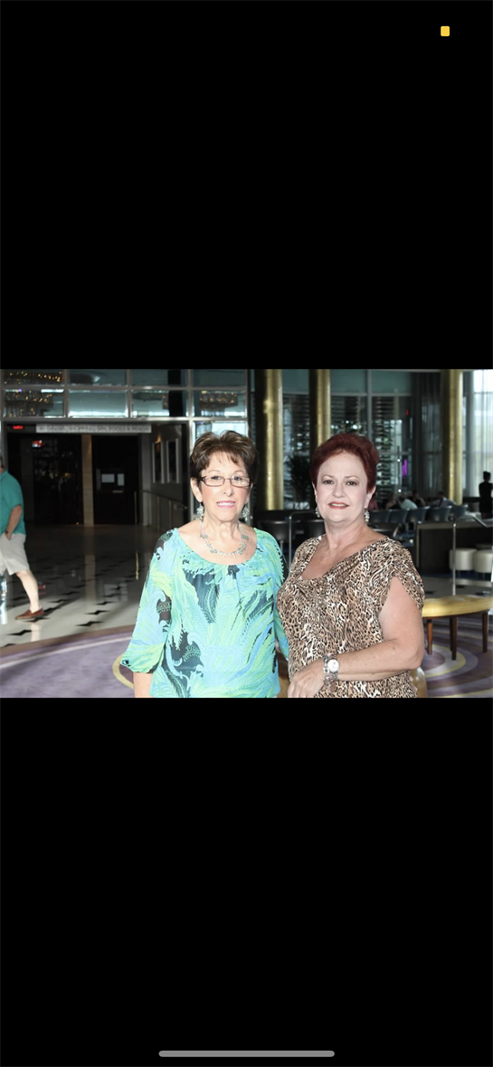 Two women engage in conversation while dressed elegantly in a luxurious hotel setting.