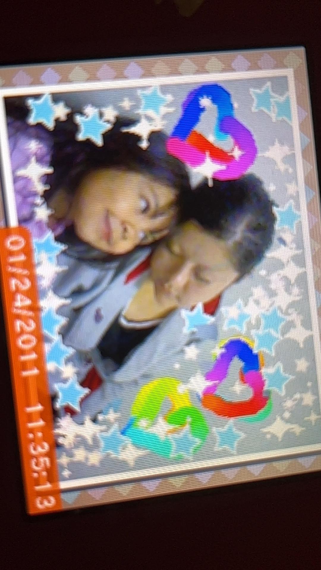 Two friends share a playful moment surrounded by colorful designs and hearts.