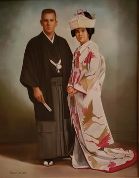 Man and woman dressed in traditional Japanese clothing stand together, smiling in a studio.