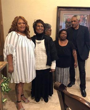 Family members pose together, sharing joy and warmth in a comfortable home atmosphere.