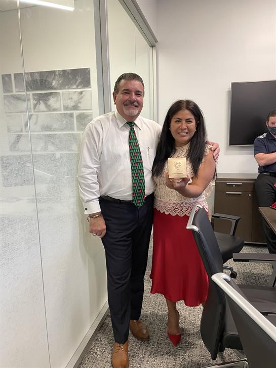 Colleagues gather in a bright office space to celebrate a significant achievement together.