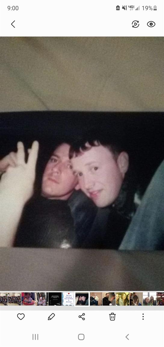 Two friends are posing for a selfie while having a good time in a relaxed setting.