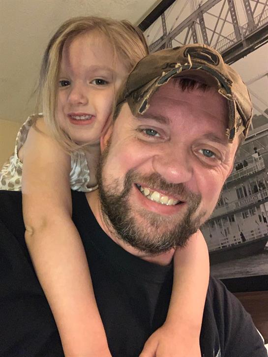 Father and daughter share a joyful moment at home, highlighting their loving relationship.