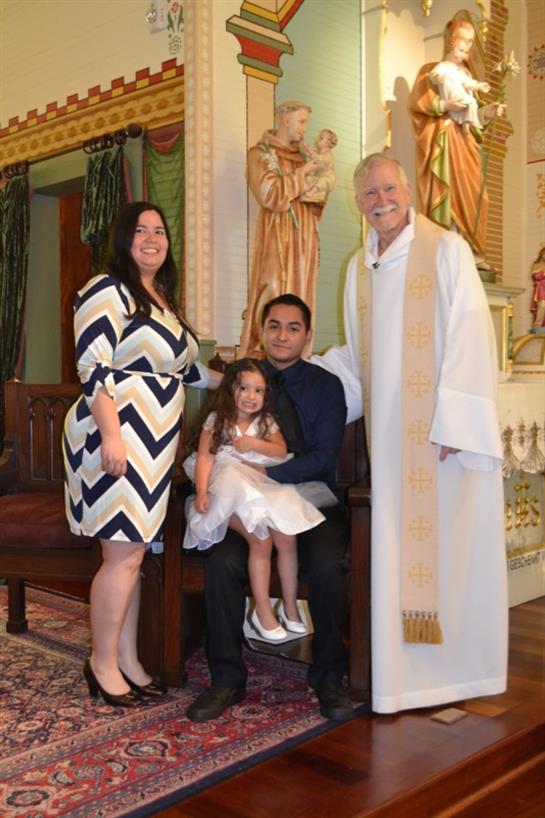 A family enjoys a special baptismal moment, capturing smiles and memories together in a church.