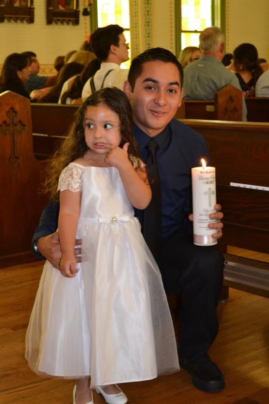 Father holds a candle while his daughter poses with a thoughtful expression, both dressed elegantly.