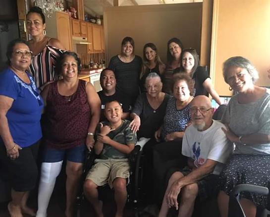 Groups of family members and friends share laughter and joy in a warm kitchen during a reunion.