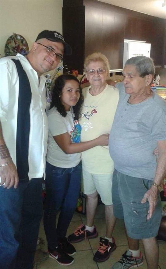 Four family members enjoy each other's company in a cheerful indoor setting.