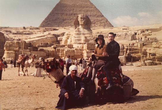 Tourists ride camels by the Great Pyramid and Sphinx, savoring the historic scenery.