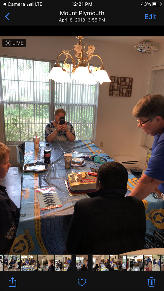 Family members come together to celebrate a birthday with cake and gifts in a cheerful atmosphere.
