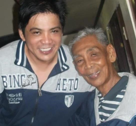 Two men, one young and one older, smile warmly as they enjoy their time together.