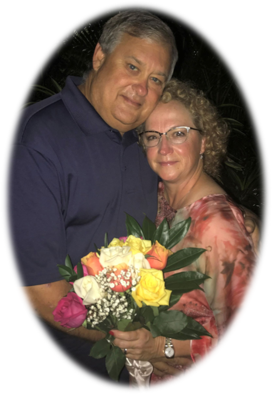 A couple shares a tender moment under the night sky with a vibrant bouquet of roses.