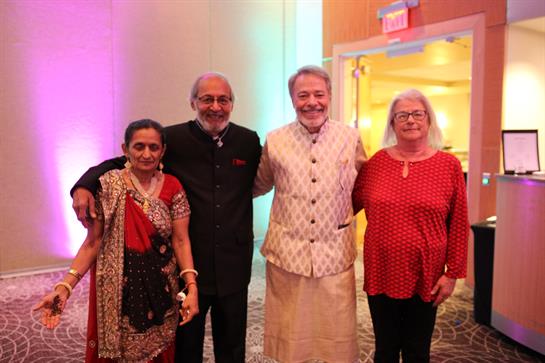 Group of friends smiles while posing together in brightly lit venue during celebration.