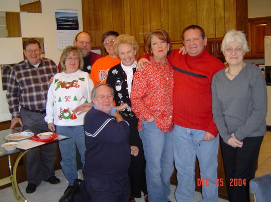 A joyful group gathers warmly, dressed casually, embracing the festive spirit.