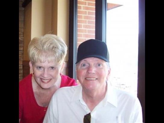 Happy couple poses together in a restaurant, enjoying each other's company over a meal.