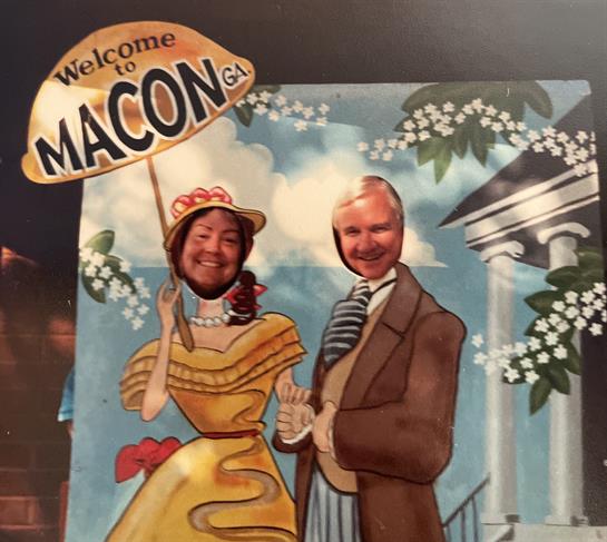 People enjoy a fun photo opportunity at a whimsical cutout stand in Macon, Georgia.
