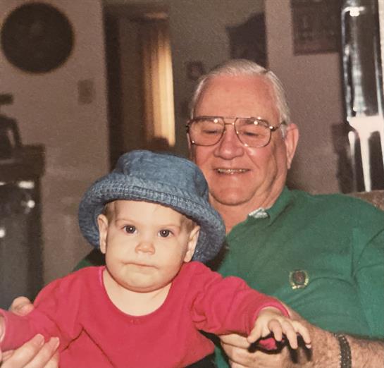 A grandfather holds his grandchild, enjoying a warm moment in their comfortable home.