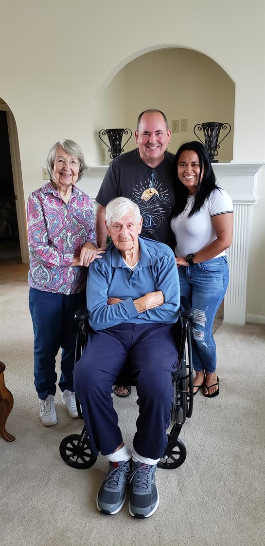 Four family members pose joyfully in a comfortable living room, showcasing their bond.