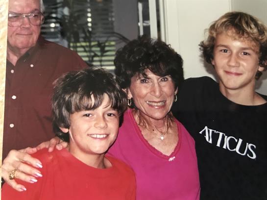 A loving family smiles warmly together in their cozy living room during a special gathering.