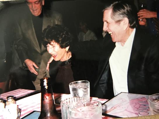 Friends enjoying a lively dinner at a bustling restaurant, full of laughter and conversation.