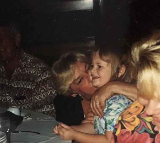 Adults and children enjoy a lively gathering at a restaurant, sharing laughter and smiles together.