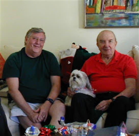 Two friends enjoy each other's company, surrounded by decorations in a warm living room setting.