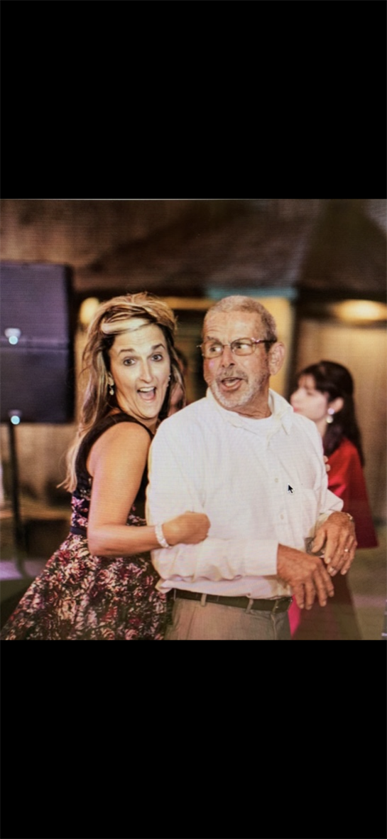 A woman and an older man are happily dancing together at a festive gathering in the evening.