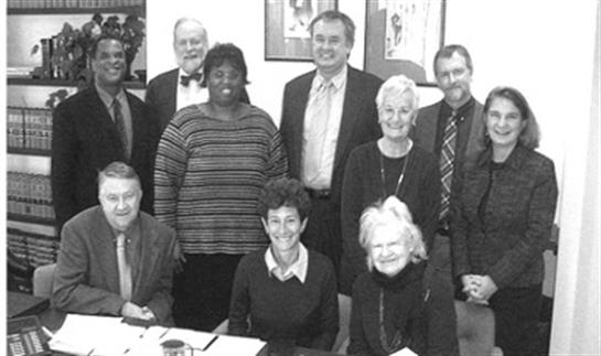 A diverse group shares smiles and camaraderie in a meeting space.