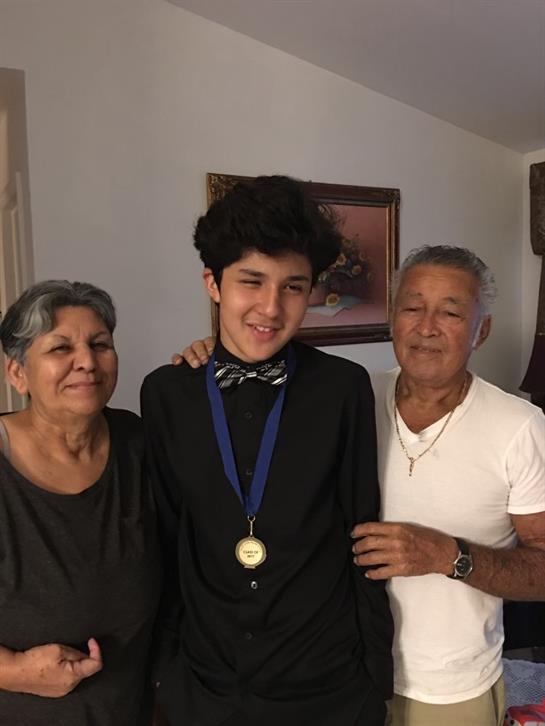 Family members joyfully celebrate a recent accomplishment as they gather in a cozy living space.