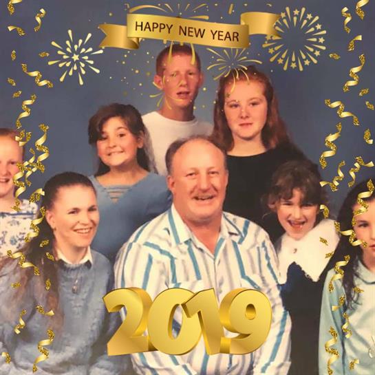 A cheerful family gathers to celebrate New Year's Eve, showcasing smiles and excitement for 2019.