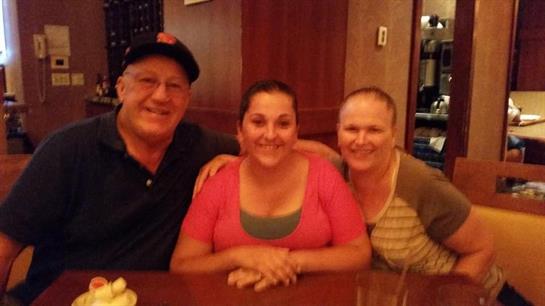 Three friends gather at a restaurant table, sharing smiles and enjoying their time together.