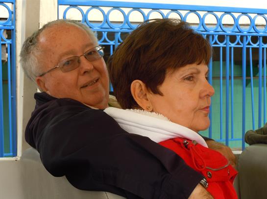 A couple sits close together, enjoying each other's company with smiles and warmth.