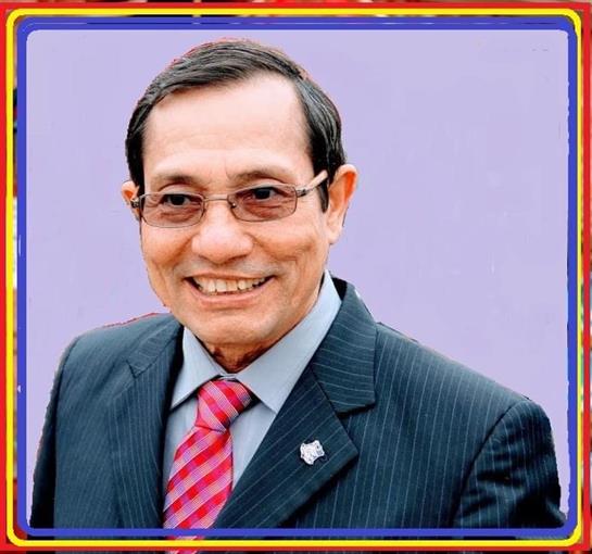 A well-dressed man smiles confidently, showcasing professionalism with a friendly demeanor.