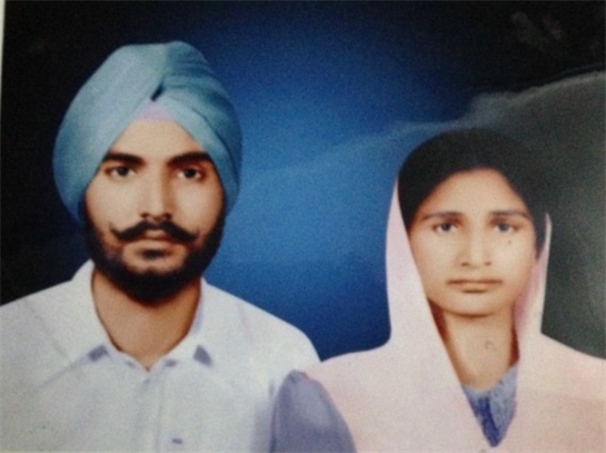 A couple in traditional attire poses in a vibrant setting, celebrating their cultural heritage.