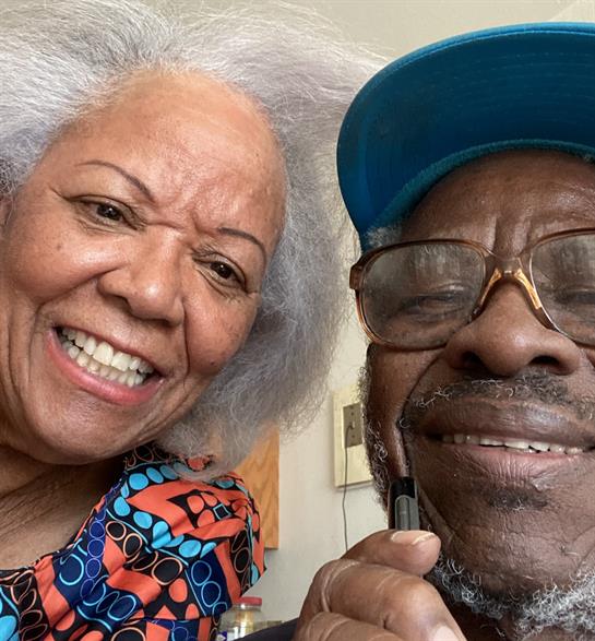 Two seniors share joyful expressions while spending time together at home.