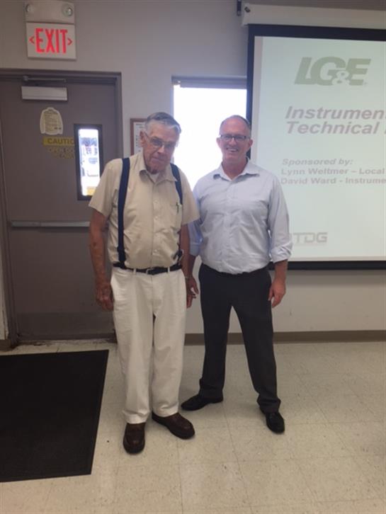 Two professionals meet in a training room at a technical conference for specialists.