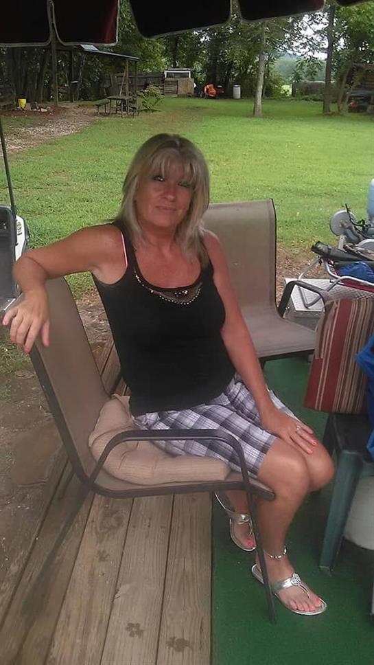 A casual day in the backyard where a woman relaxes on a comfortable chair surrounded by greenery.