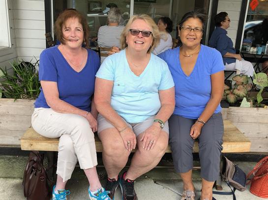Friends enjoy each other's company outdoors in matching outfits during a gathering.