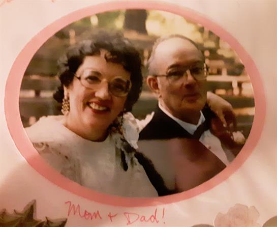 A couple stands closely together, smiling and enjoying a day filled with happiness and celebration.