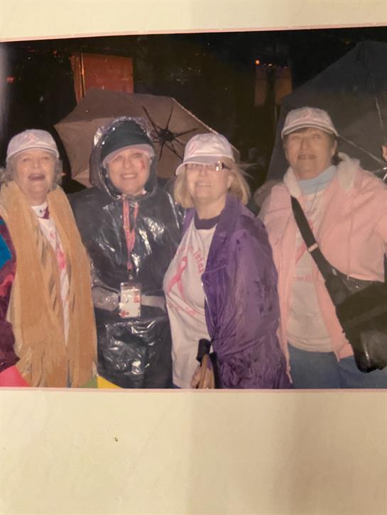 Friends gather under umbrellas, smiling and bonding during a rainy night at the city festival.