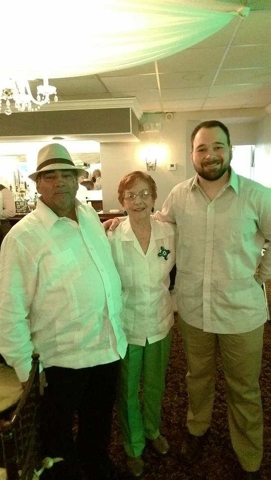 Three individuals pose together, showcasing joy and warmth in a vibrant dining atmosphere.