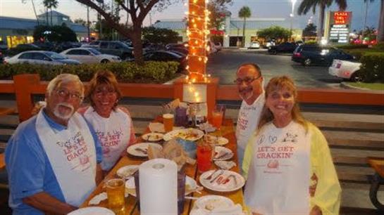Group of friends share laughter and food at a vibrant outdoor dining spot in the evening.