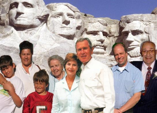A family stands together in front of Mount Rushmore, enjoying their visit on a sunny day.